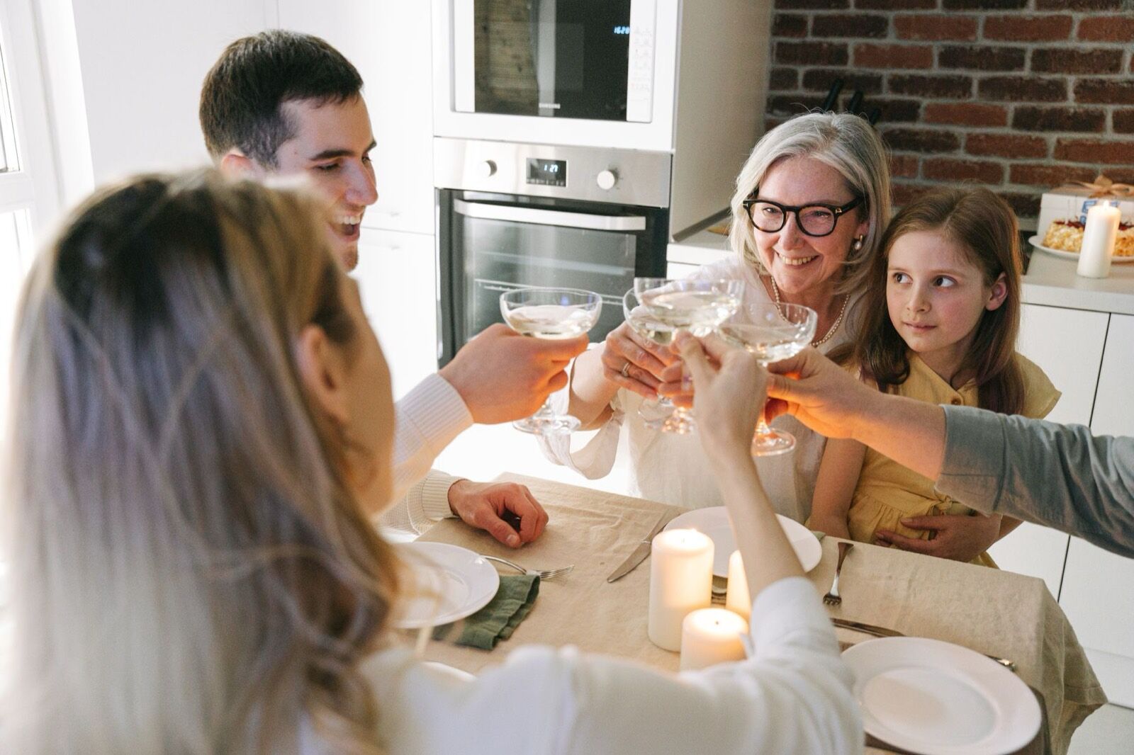A family of several generations raising glasses over a candlelit dinner