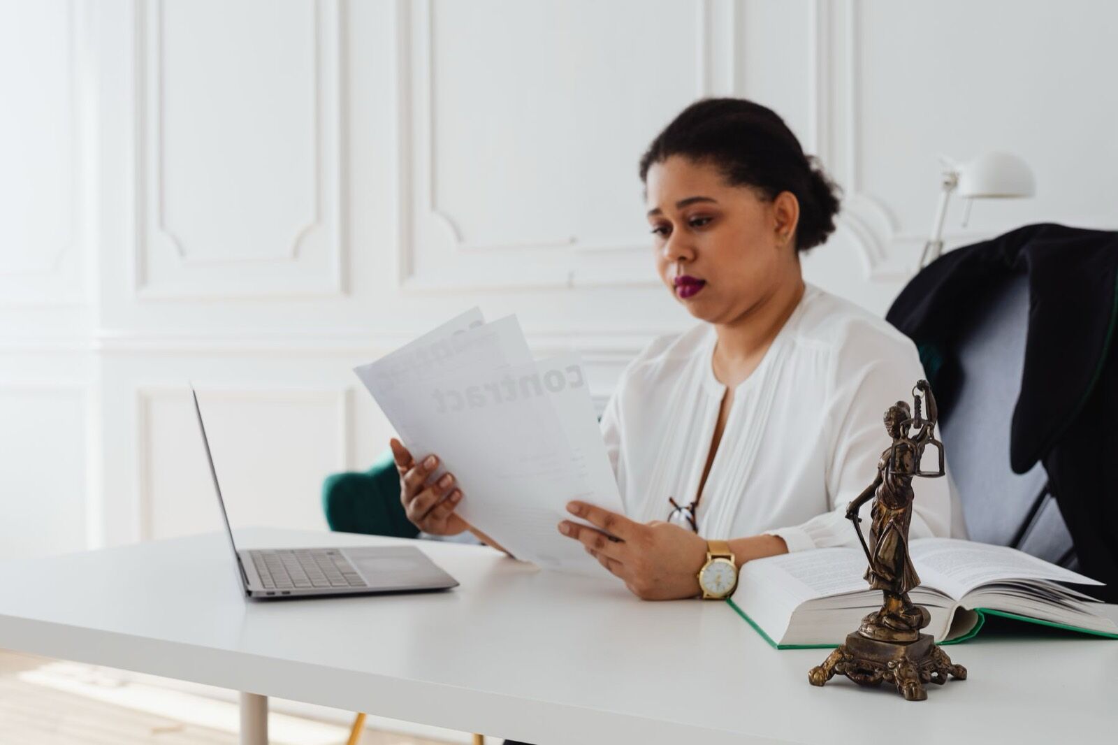 A practitioner reading legal papers at her desk